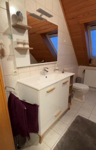 a white bathroom with a sink and a toilet at snevernheimat, Ferienwohnung in Schneverdingen