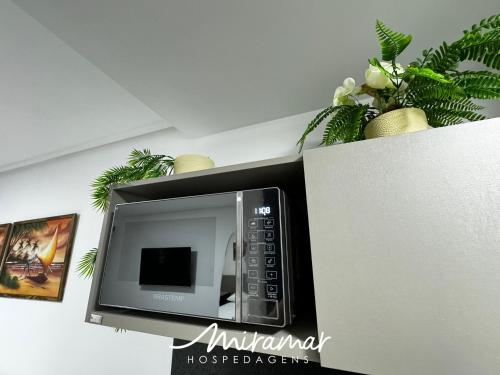 a microwave sitting on top of a wall at Move - Tambaú in Tambaú