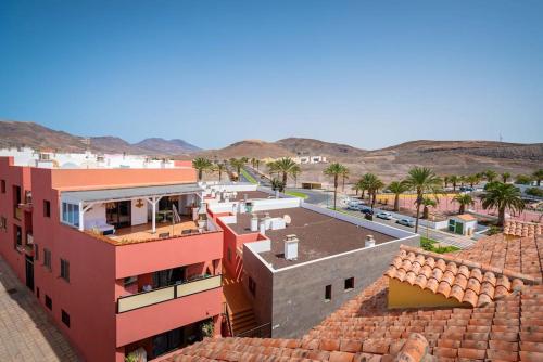 arial view of a building with palm trees and a street at Ático San Agustín in La Lajita
