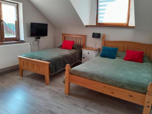 a bedroom with two beds and a television in it at Pod Żurawiem in Bóbrka