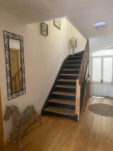 un escalier dans une maison avec un miroir et une cage d'escalier dans l'établissement La Castalie, à Plombières-les-Bains