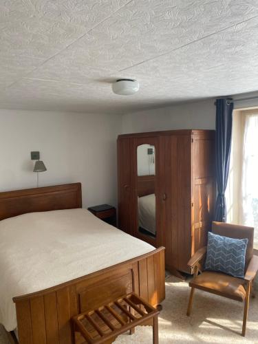 une chambre avec un lit, une chaise et un miroir dans l'établissement La Castalie, à Plombières-les-Bains