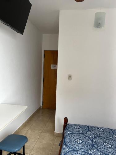 a room with a bed and a chair and a door at Hosteria Prince in Chajarí