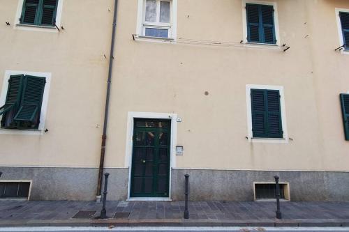 a building with a green door and three windows at Via Vernazza 30 mt dal mare in Cogoleto