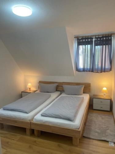 two twin beds in a room with a window at Ferienwohnung Dinh in Uhldingen-Mühlhofen