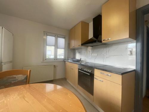 a kitchen with a table and a stove and a sink at Ferienwohnung Dinh in Uhldingen-Mühlhofen