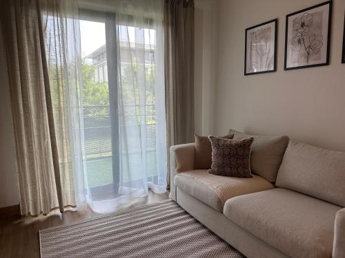 un salon avec un canapé et une grande fenêtre dans l'établissement Suite Alya Appartement proche Disneyland, à Marne-la-Vallée