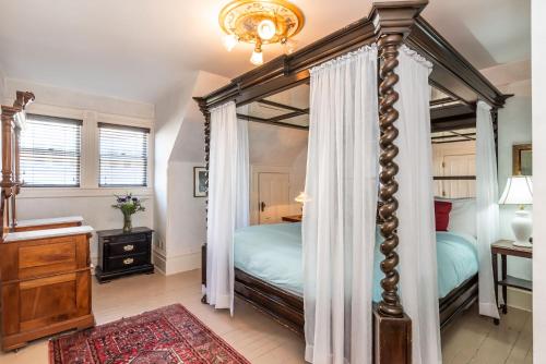 a bedroom with a four poster bed with a canopy at Chateau Tivoli Bed and Breakfast in San Francisco