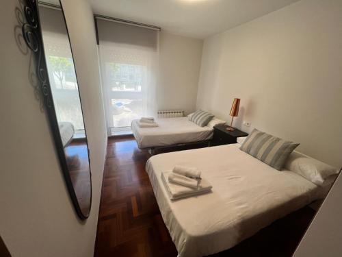 a small room with two beds and a mirror at Mártires de Carral in Santa María