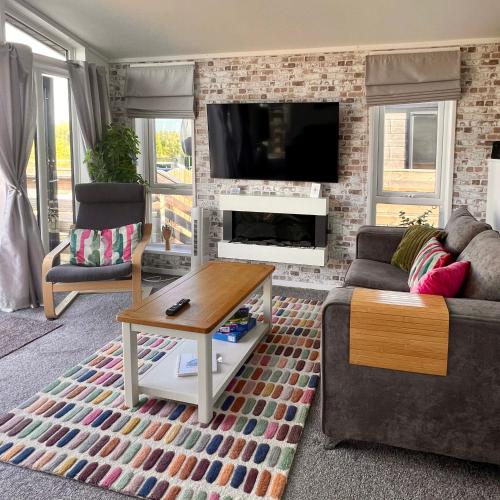 a living room with a couch and a fireplace at Willow's Lakeside Lodge With Hot Tub & Hi-Speed Wifi in Stamford