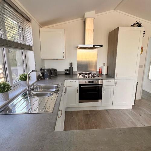 a kitchen with white cabinets and a sink at Willow's Lakeside Lodge With Hot Tub & Hi-Speed Wifi in Stamford