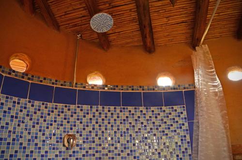 uma casa de banho com um chuveiro de azulejos azuis com luzes em Mawasi Finca em Villa de Leyva