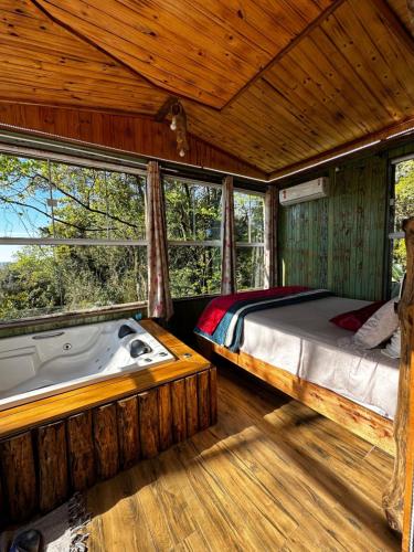 a bedroom with a bed and a bath tub at Pousada Vale de Luz FW in Frederico Westphalen
