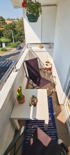 a table and a chair on a balcony at Dina cozy apartment in Zemun