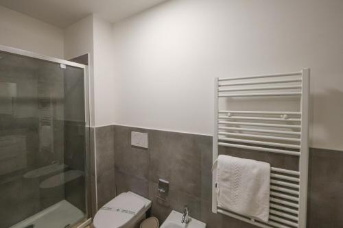 a bathroom with a toilet and a glass shower at Residence della Accademia in Modena