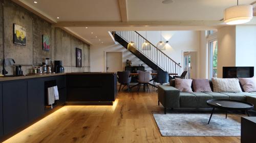 a living room with a couch and a dining room at Schwarzwald Chalet Auwald in Freiamt