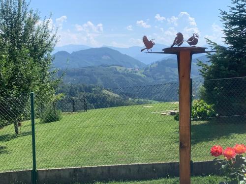 three birds sitting on a bird feeder on a fence at Auszeit 2 0 Digital Detox in Obergrünburg