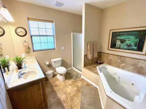 a bathroom with a tub and a toilet and a sink at Rockwood Condos on Table Rock Lake With Boat Slips in Branson