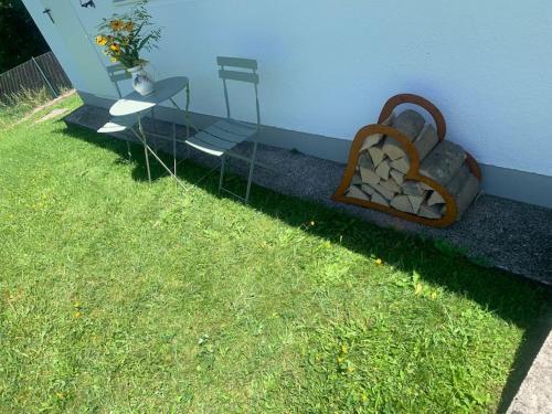 a patio with two chairs and a table in the grass at Auszeit 2 0 Digital Detox in Obergrünburg
