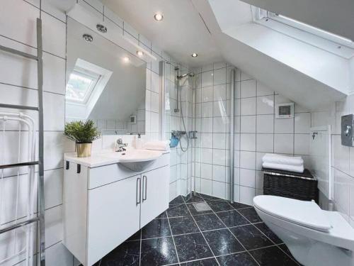 a white bathroom with a sink and a toilet at Apartment with Loft & Window Balcony, Free parking in Bergen