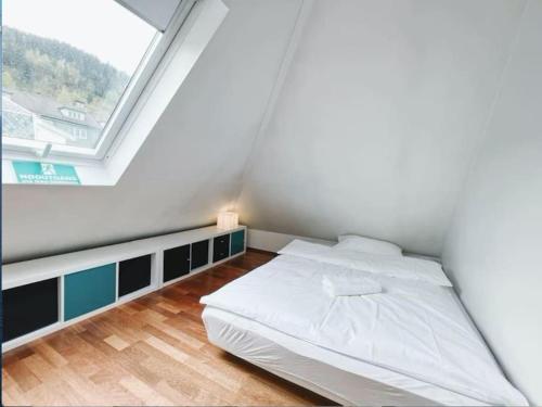 a white bed in a room with a window at Apartment with Loft & Window Balcony, Free parking in Bergen