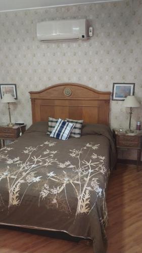 a bedroom with a bed and two night tables with lamps at Gustavo in Villa Mercedes