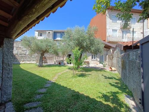 a yard with a stone wall and a house at Casa do Jardim in Guimarães