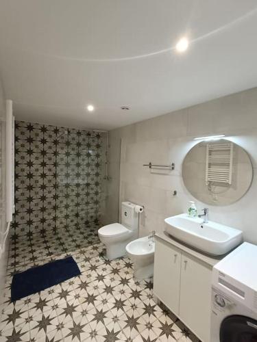 a bathroom with a sink and a toilet and a mirror at Casa do Jardim in Guimarães