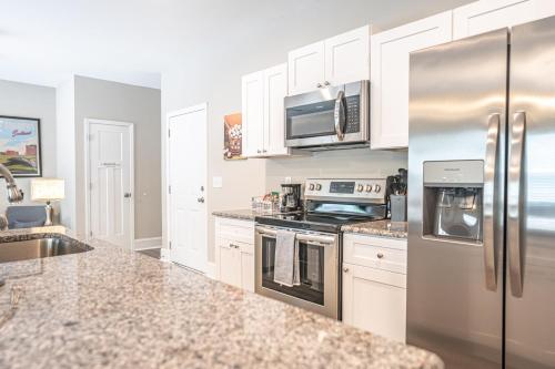 a kitchen with white cabinets and stainless steel appliances at The Sequoia at Ducks Landing in Aberdeen