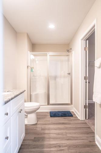 a white bathroom with a toilet and a shower at The Sequoia at Ducks Landing in Aberdeen