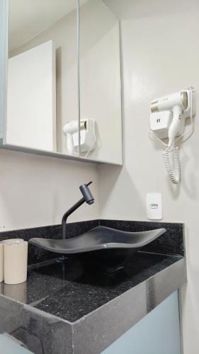 a sink in a bathroom with a mirror at 04 - Apto Studio Liberdade Sé 500'Metrô in São Paulo