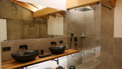 a bathroom with two sinks and a shower at Schwarzwald Chalet Auwald in Freiamt
