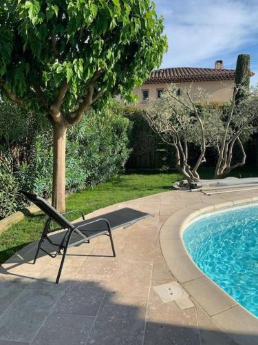 une chaise près de la piscine dans une cour dans l'établissement Beautiful AC house with swimming pool Aix center, à Aix-en-Provence