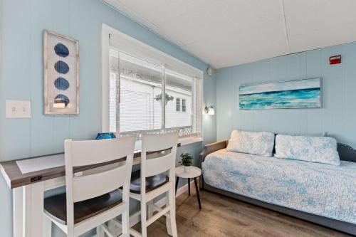 Un dormitorio con una cama, un escritorio y una mesa. en Cozy 1-Bedroom Suite Steps from the Beach (464), en Old Orchard Beach