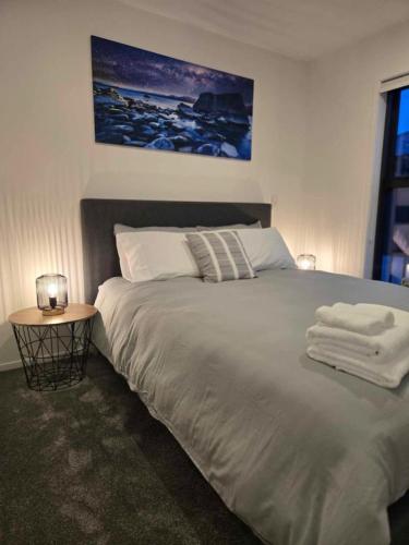 a bedroom with a large bed with towels on it at CBD Apartment 3 - 2 Bed 2 Bath in Christchurch