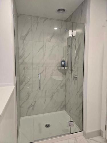 a shower with a glass door in a bathroom at CBD Apartment 3 - 2 Bed 2 Bath in Christchurch