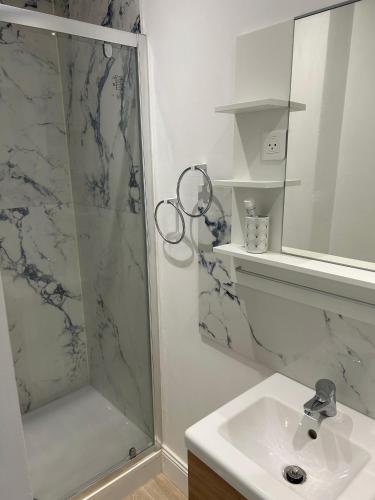 une salle de bain avec douche et lavabo dans l'établissement Equilibrium Family House by E, à Roubaix