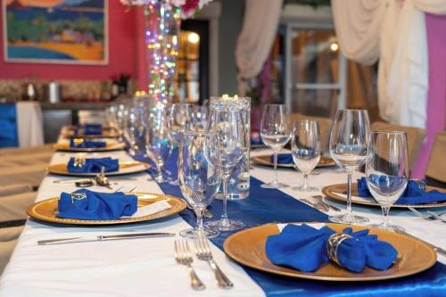 a table with plates and glasses and blue napkins at Culturally Luxurious Villa- ViewFort Estate in Ebenezer