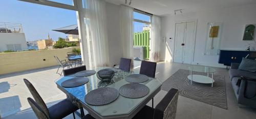 a dining room with a table and a balcony at Penthouse Cathedral and Seaview Terrace V2 in Valletta