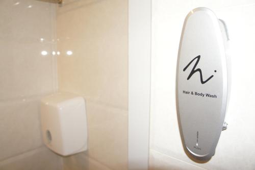 a bathroom with a surfboard on the wall next to a urinal at Homy Inn North Point in Hong Kong
