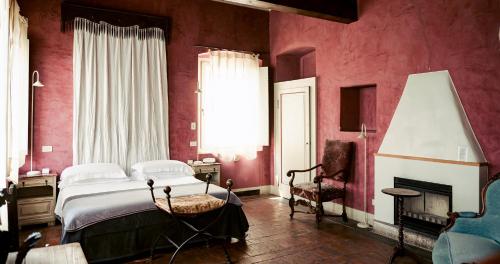 a bedroom with red walls and a bed and a chair at Cappuccini Resort in Cologne