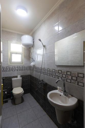 a bathroom with a toilet and a sink at Hyat Suites & Rooms in Alexandria