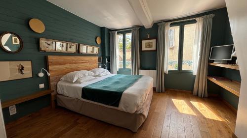une chambre aux murs verts avec un lit et une télévision dans l'établissement La Moussette, à Honfleur