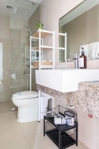 a bathroom with a white sink and a toilet at Tree of Life Penthouse 3BR w Gym Pool Sauna More in Manila