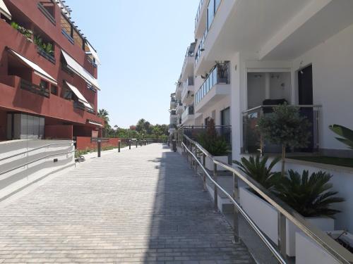 an empty sidewalk next to some apartment buildings at Costa Tropical Comfortable Apartment Playa Granada in Motril