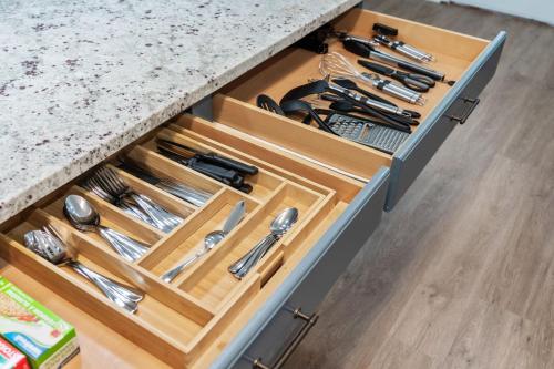 a kitchen drawer with wooden drawers filled with utensils at The Dreamy Getaway House in Spring in Spring