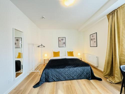 a bedroom with a bed with a black blanket at aday - Sunny Studio Apartment in Aalborg