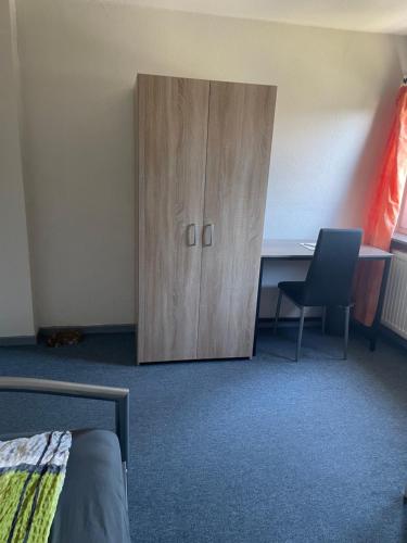 a bedroom with a wooden cabinet and a desk at Familie Alber 2P in Elze