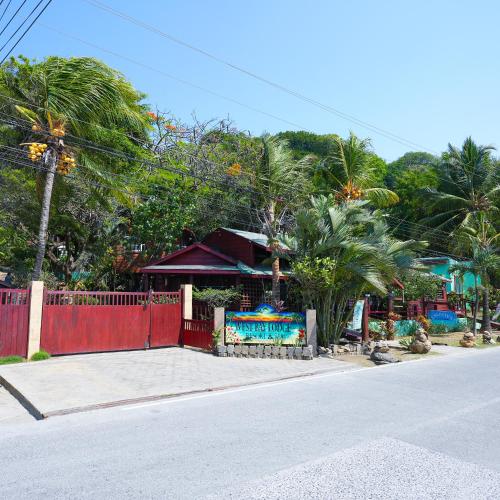 a house with a red fence next to a street at West Bay Lodge and Spa in West Bay