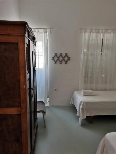 a room with a bed and a dresser and a bedroom at Thalassa4 in Andros